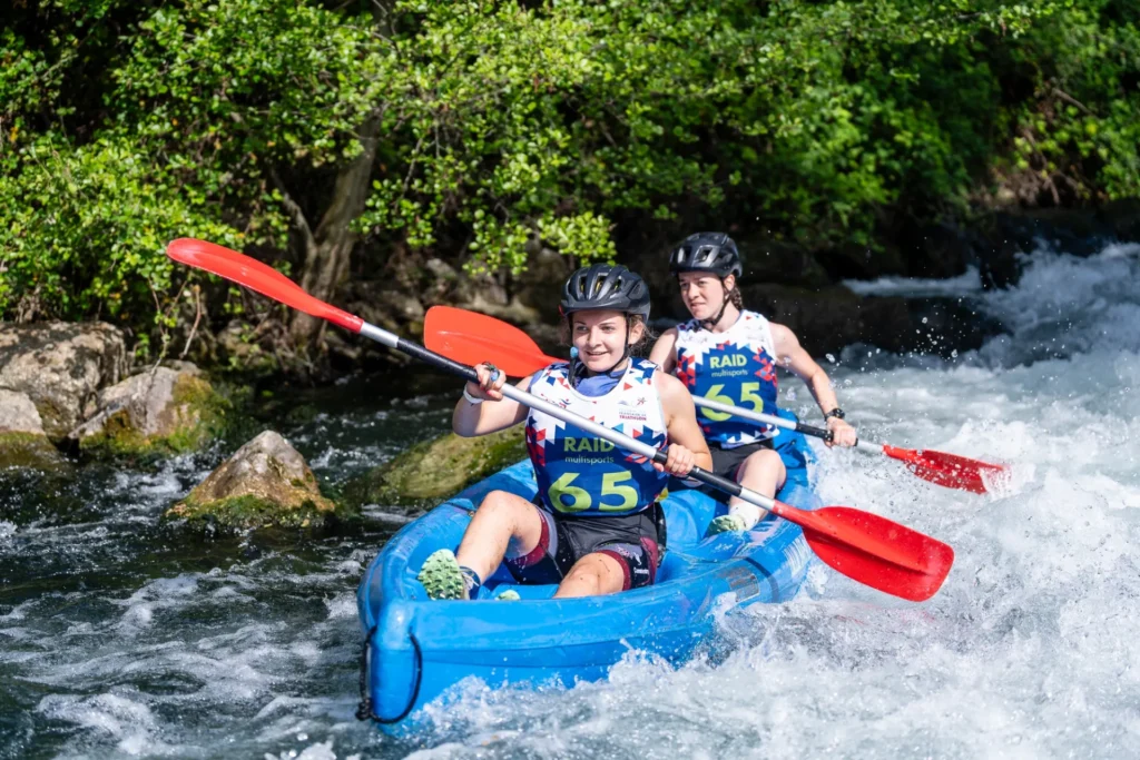 Deux équipiers du CAP 03 franchissent un rapide en canoë biplace lors d'un raid multisport